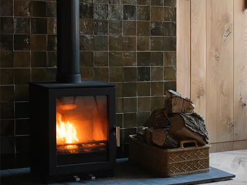 Tiled fireplace with dark zellige tiles